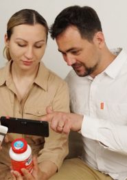 a couple using zoomax luna 6 handheld video magnifier to look at pill bottle
